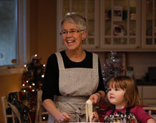 Load image into Gallery viewer, Grandmother baking in indigo striped Hovden Wear apron. Her granddaughter is next to her.
