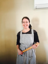 Load image into Gallery viewer, A baker in a blue striped Hovden Wear apron, holding a rolling pin.
