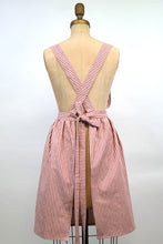 Load image into Gallery viewer, Red and white striped Hovden Wear apron, back view. Straps cross in the back.
